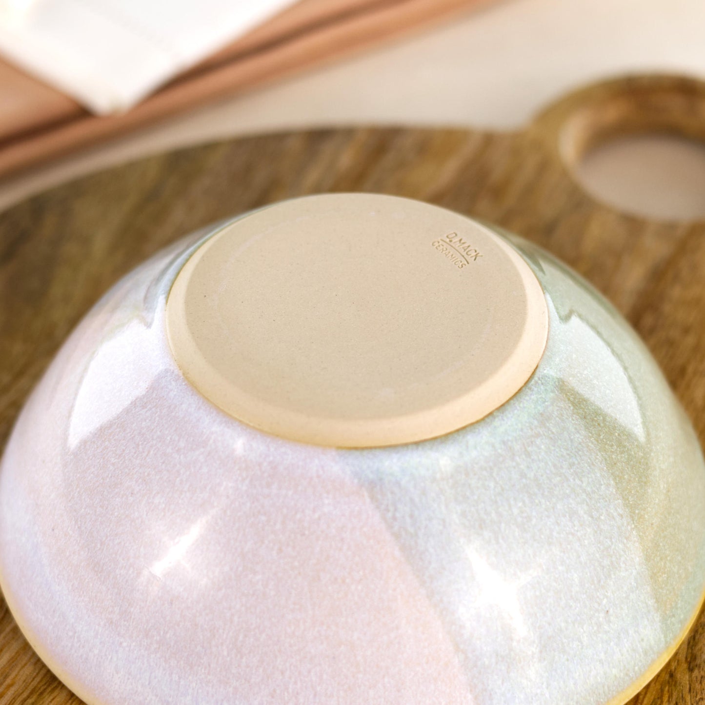 Base of Pale Green and White handmade medium bowl showing my maker’s mark and smooth burnished foot, designed to help reduce surface scratching
