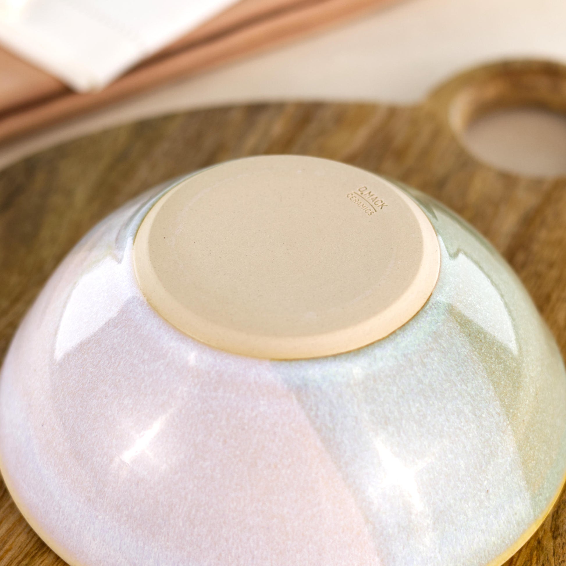 Base of Pale Green and White handmade medium bowl showing my maker’s mark and smooth burnished foot, designed to help reduce surface scratching
