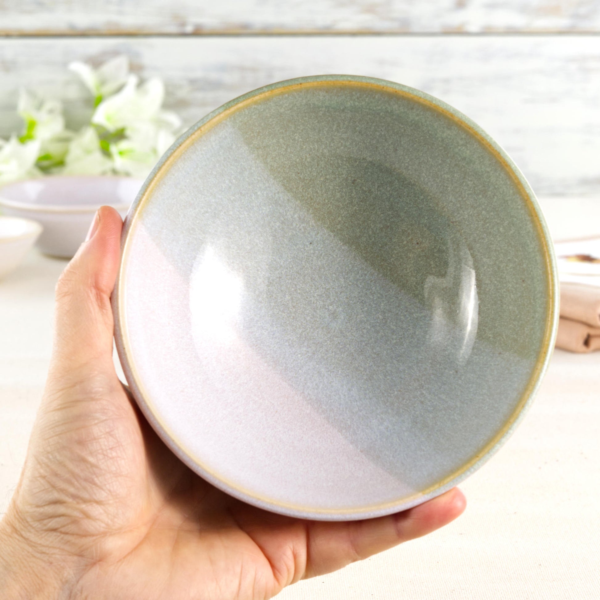 Pale Green and White handmade ceramic bowl held in hand, a medium breakfast bowl for cereal, porridge, yoghurt, soup and gentle everyday meals