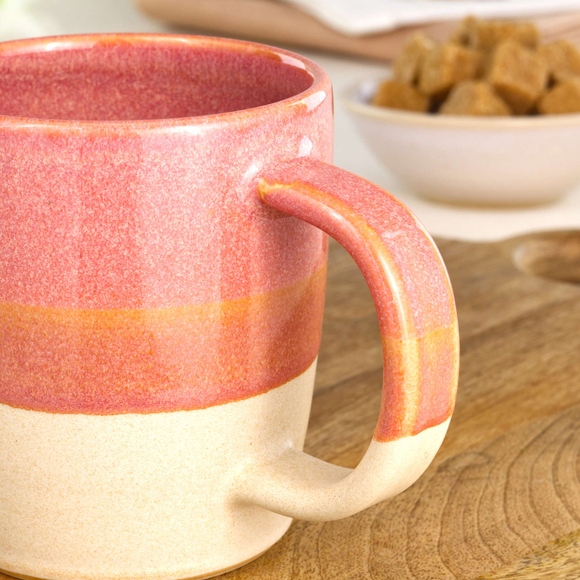 Close-up of the handle on a Coral and Sand handmade coffee mug, finished with my Sea Smoothed Pebble glaze above a sandy satin-matte base in my home studio