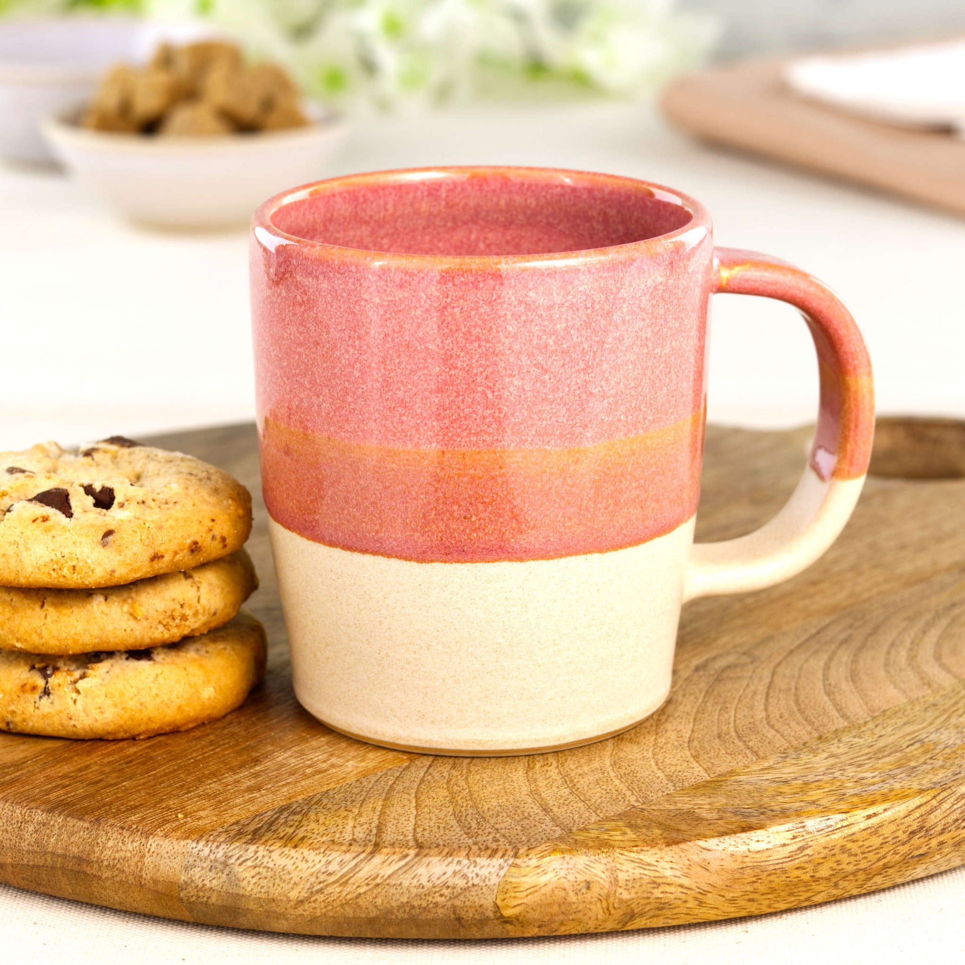 Coral and Sand artisan ceramic latte mug on a wooden board with biscuits, a handmade stoneware mug from my Sussex home pottery studio