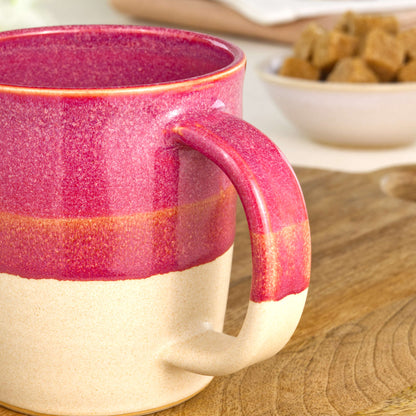 Close-up of the handle on a Crimson and Sand handmade coffee mug, finished with glossy Sea Smoothed Pebble glaze above a sandy satin-matte base in my home studio
