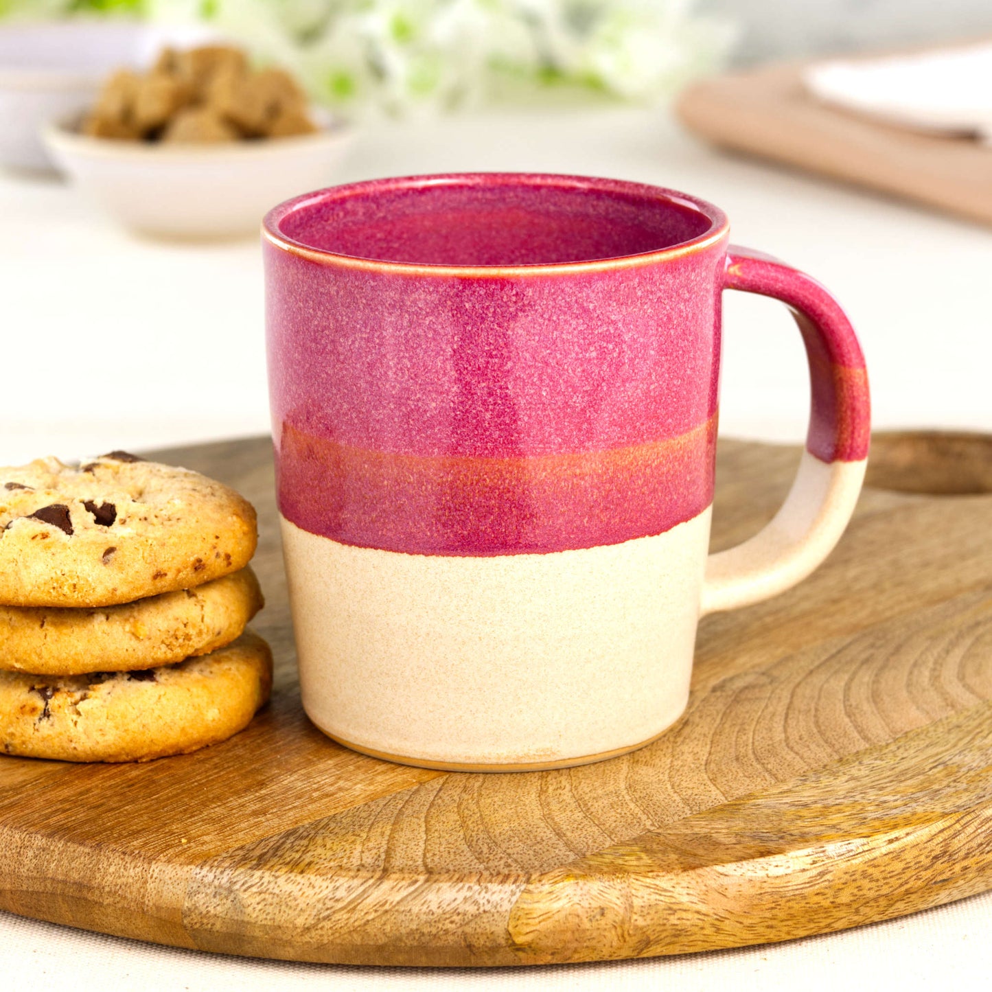Crimson and Sand artisan ceramic latte mug on a wooden board with biscuits, a handmade stoneware mug made in my Sussex home pottery studio