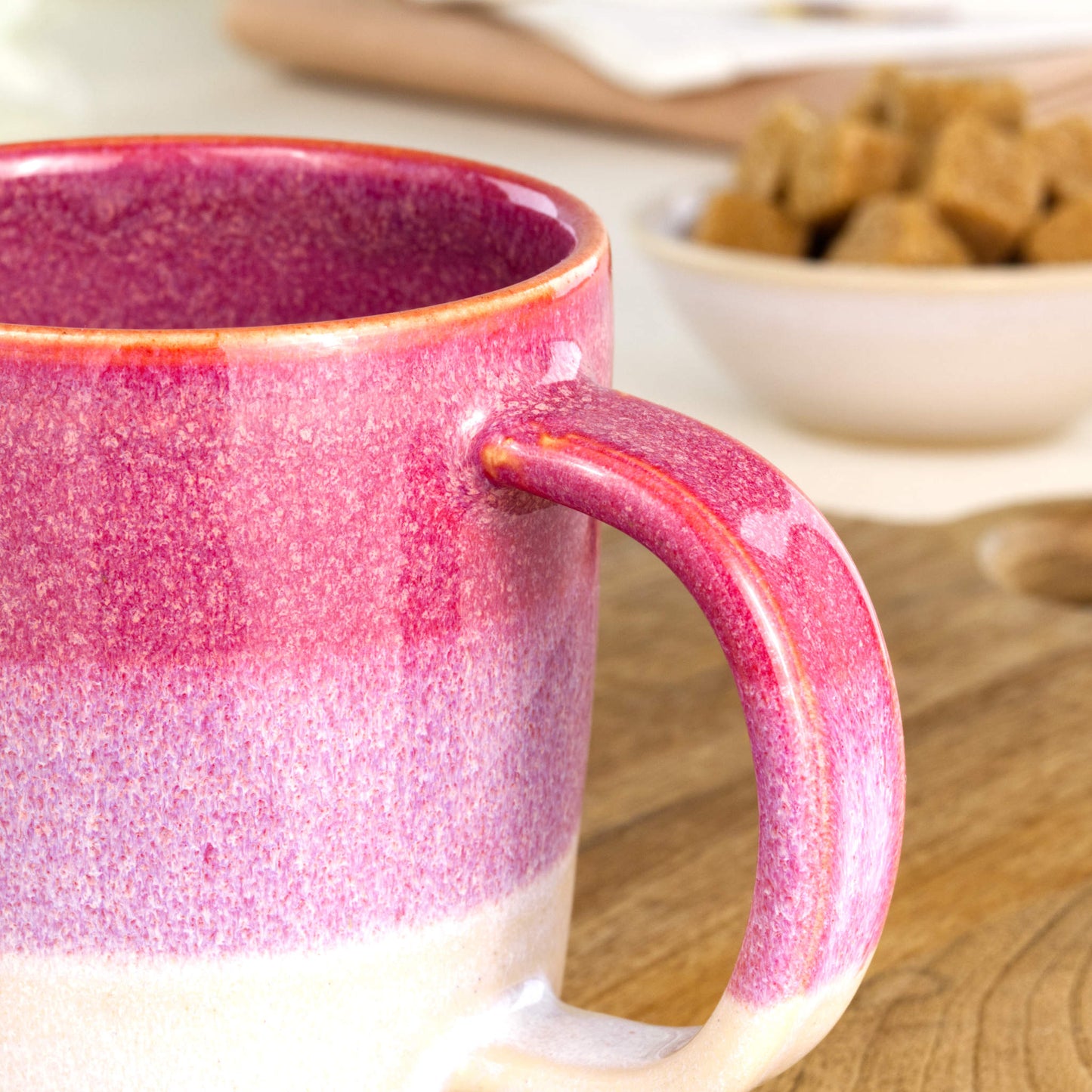 Close-up of the handle and layered Crimson and White glaze on a handmade ceramic mug from my British pottery studio