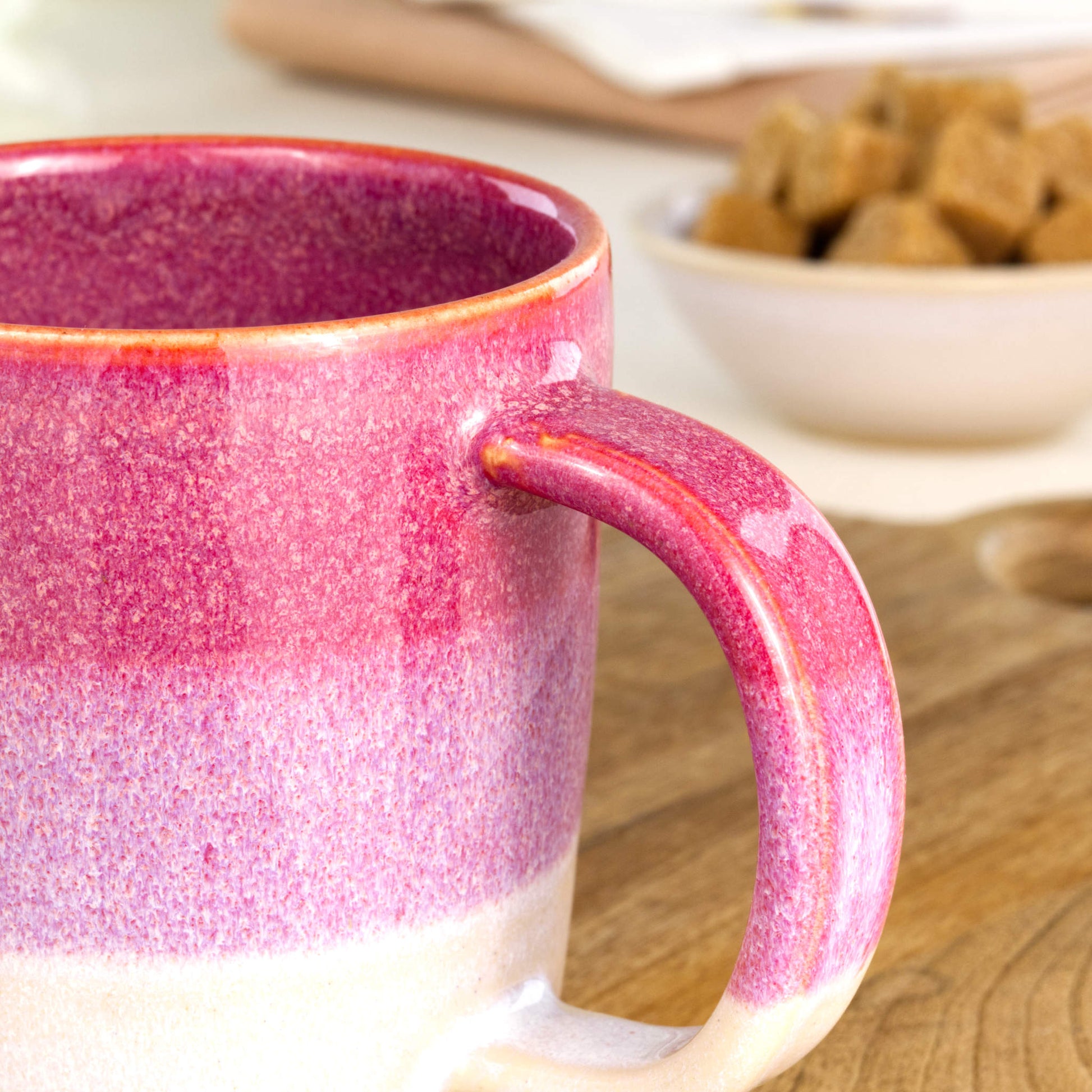 Close-up of the handle and layered Crimson and White glaze on a handmade ceramic mug from my British pottery studio