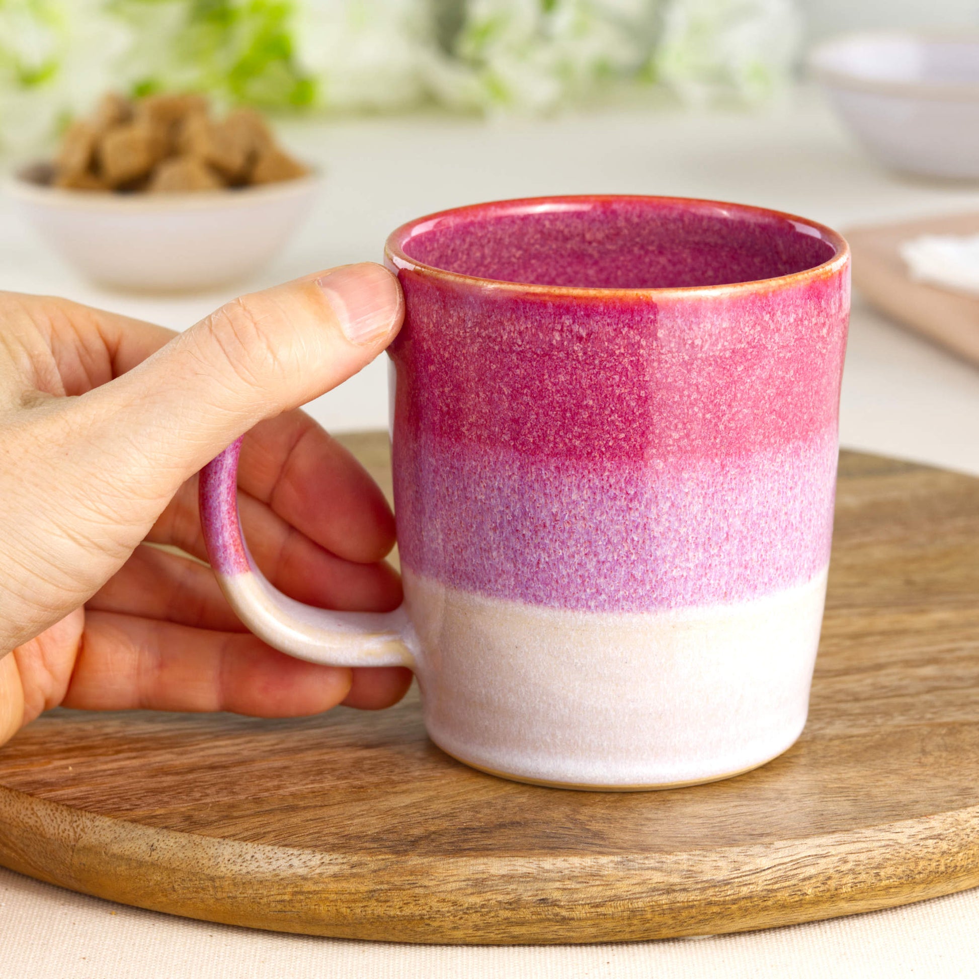 Crimson and White pottery mug shown in hand, highlighting the comfortable handle and everyday charm of this handmade tea cup