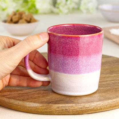 Crimson and White pottery mug shown in hand, highlighting the comfortable handle and everyday charm of this handmade tea cup