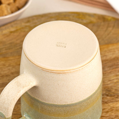 Underside of Pale Green and Sand ceramic mug showing the burnished smooth base and maker’s mark, handmade in my British studio pottery
