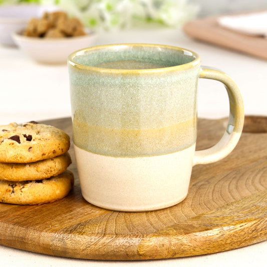 Pale Green and Sand artisan ceramic latte mug on a wooden board with cookies, a handmade stoneware mug made in my Sussex home studio