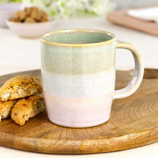 Pale Green and White handmade ceramic mug styled with biscotti on a wooden board for a cosy tea or coffee break