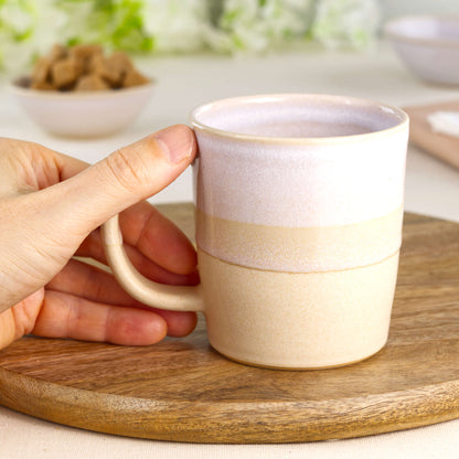 White and Sand wheel-thrown tea mug shown in hand, a warm neutral stoneware mug with soft farmhouse style made in my home pottery studio