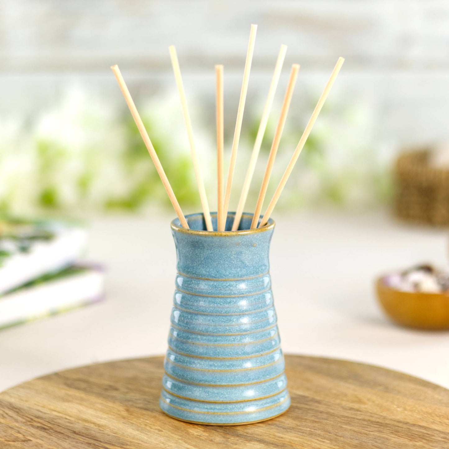 Coastal blue ribbed ceramic bud vase styled with natural reeds. Striped look.