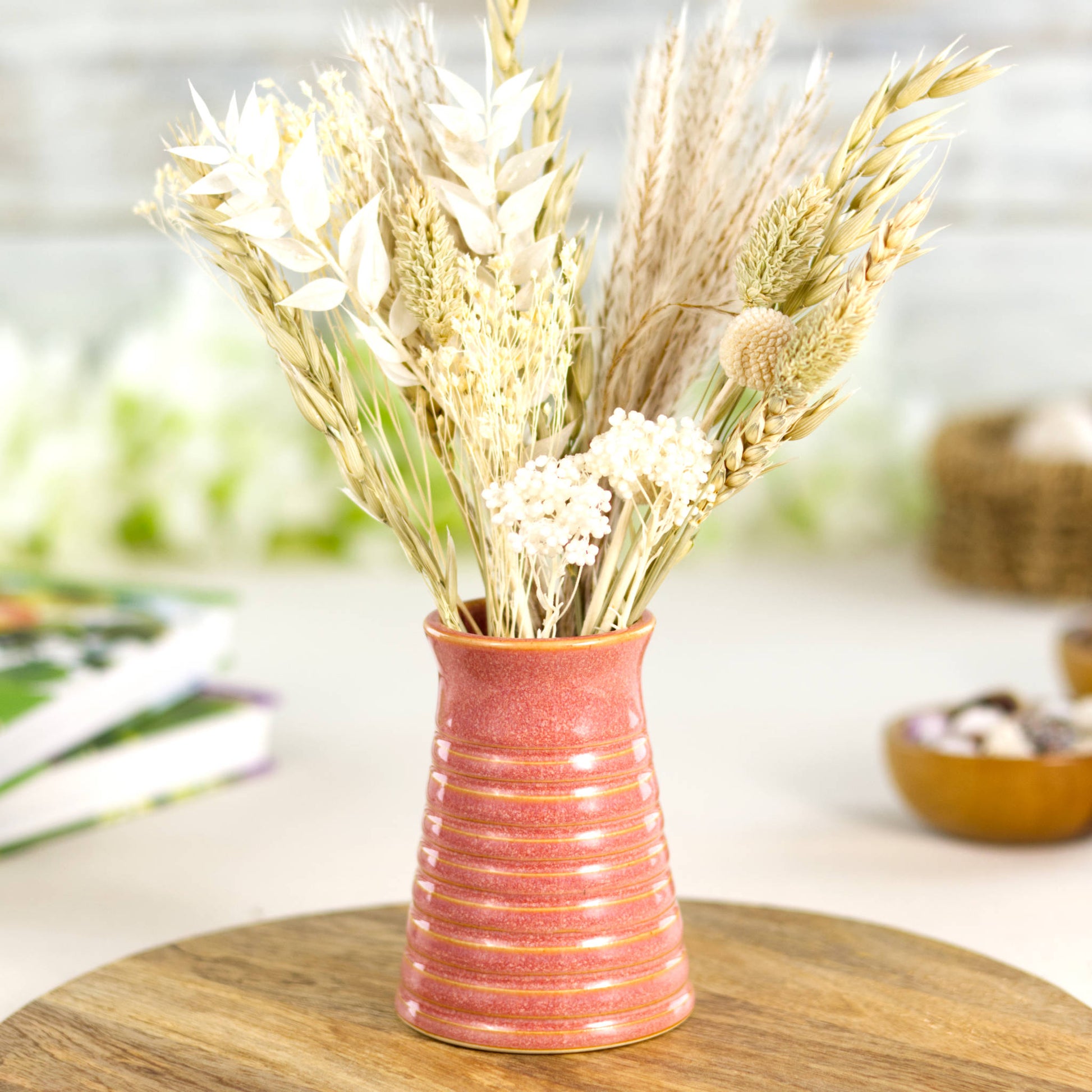 Coral ribbed ceramic bud vase styled with neutral dried grasses, complementing a soft boho aesthetic.
