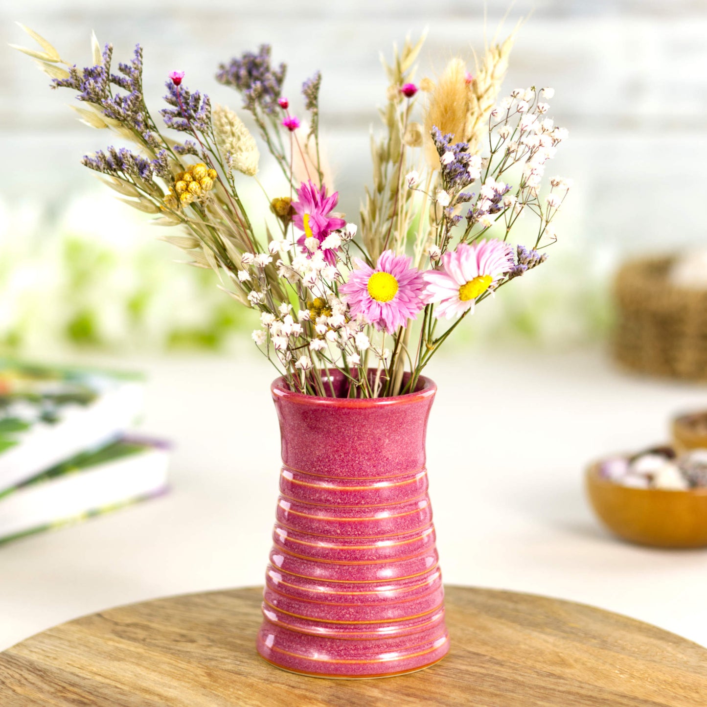 Crimson ribbed ceramic bud vase styled with colourful dried flowers, creating a vibrant decorative centrepiece.
