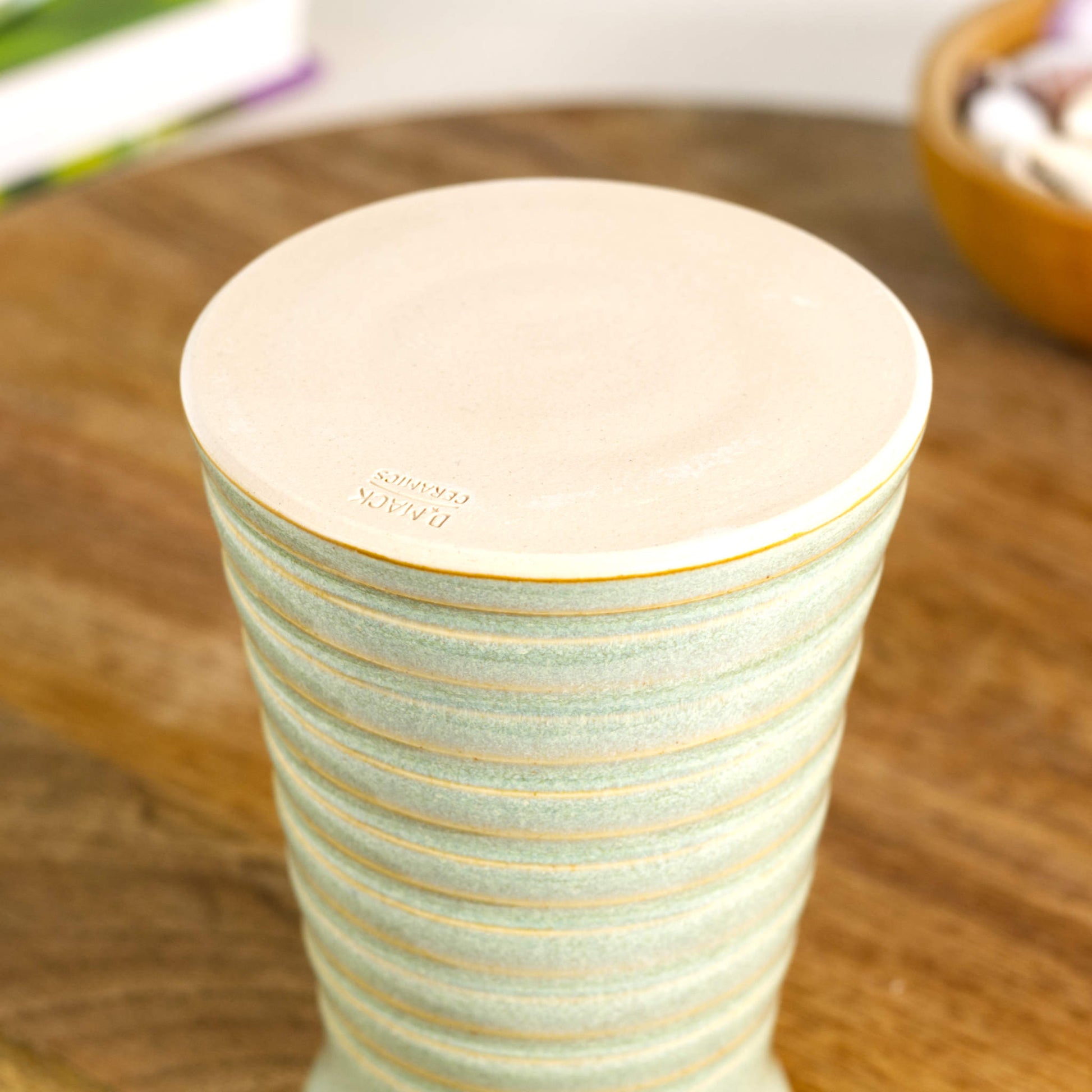Handmade pale green ribbed ceramic bud vase with maker’s mark on the base, British studio pottery.