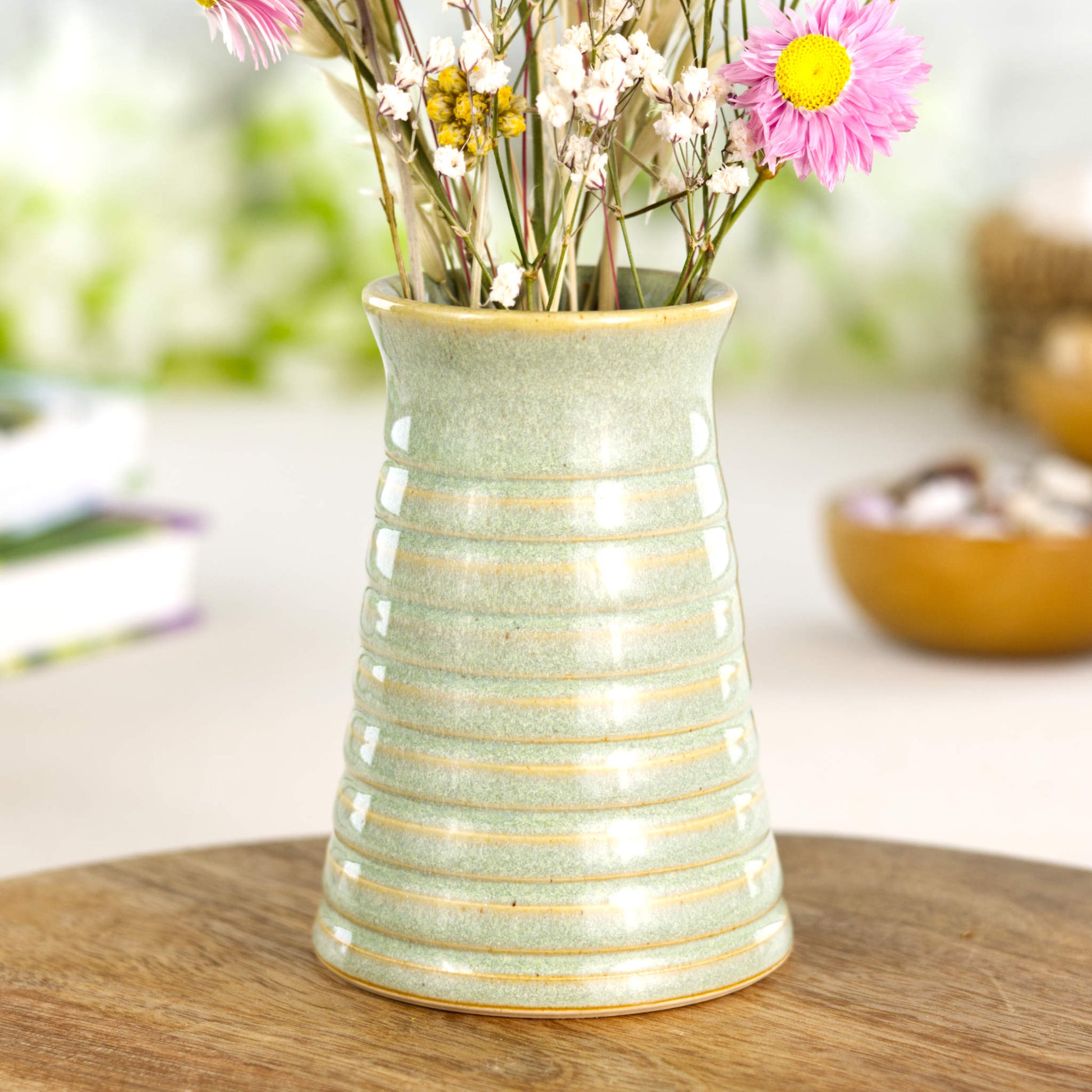 Pale green ribbed ceramic bud vase in Sea Smoothed Pebble glaze, ideal as minimalist shelf décor.