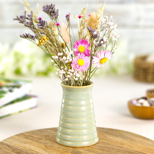 Pale green ribbed ceramic bud vase displaying colourful dried flowers, perfect for spring home décor.