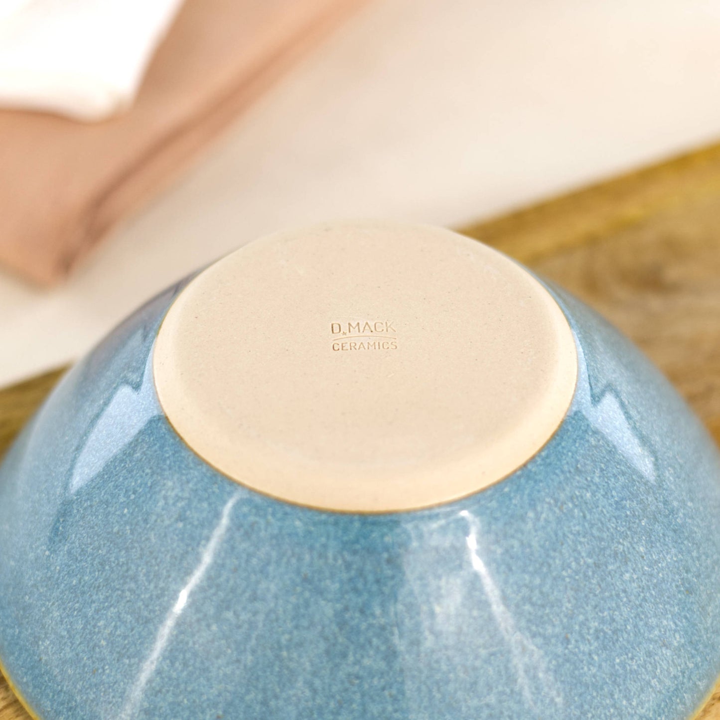 Base of handmade Coastal Blue small bowl showing smooth burnished clay and maker’s mark from my Sussex pottery studio