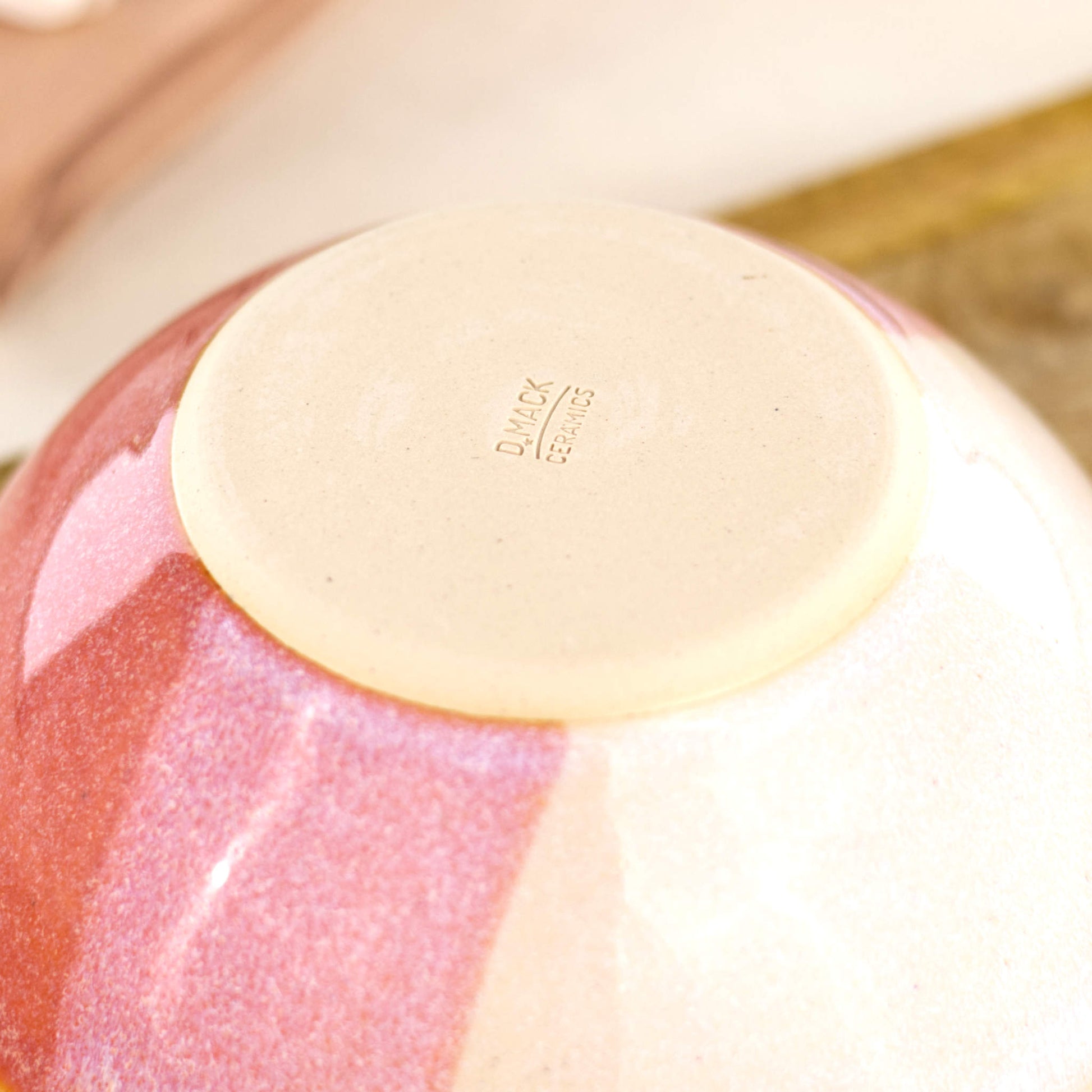 Base of Coral and White handmade small bowl showing my maker’s mark and smooth burnished foot, designed to help reduce surface scratching on tables and worktops
