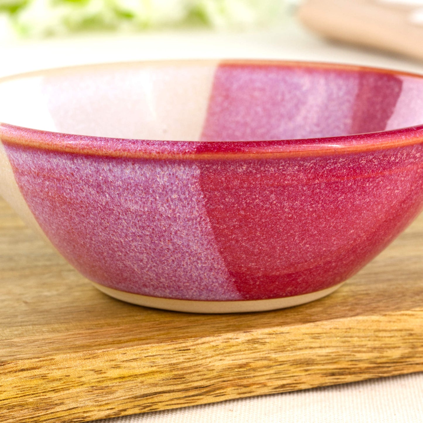 Close-up of Crimson and White double-dipped Sea Smoothed Pebble glaze on a wheel-thrown stoneware bowl, showing the rich two-tone finish and softly speckled handmade texture