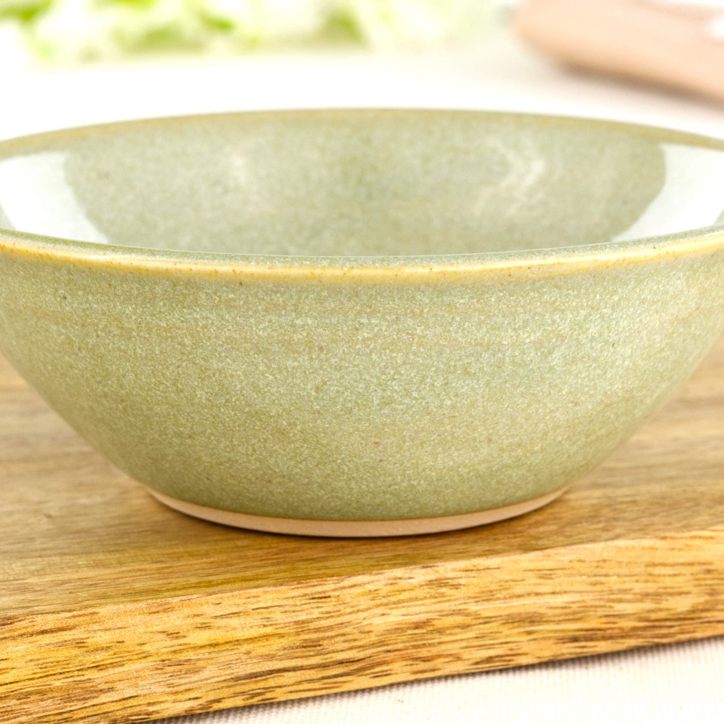 Close-up of Pale Green Sea Smoothed Pebble glaze on a wheel-thrown stoneware bowl with soft natural speckling