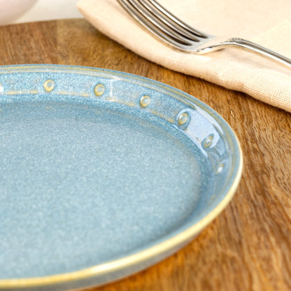 Close-up of a Coastal Blue ceramic small plate, highlighting the glossy speckled glaze, hand-finished dotted rim and rich blue stoneware finish