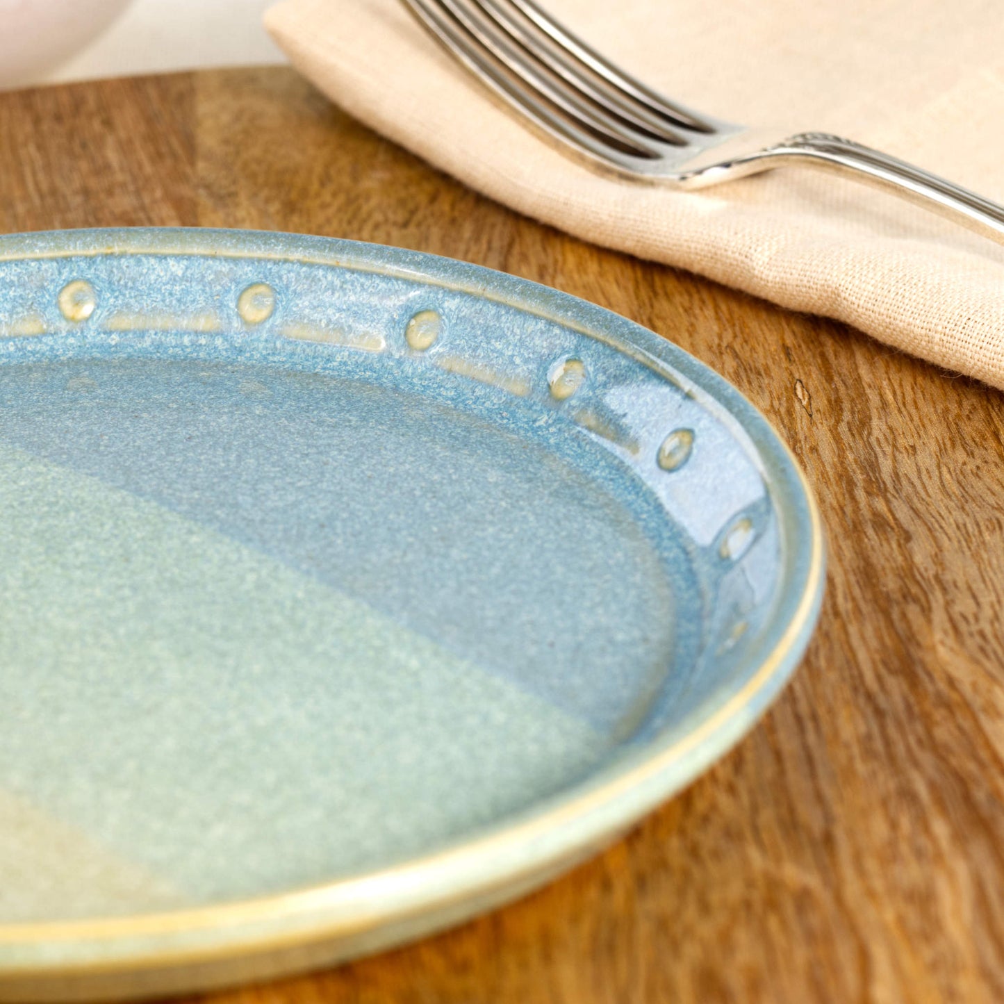 Close-up of a Coastal Blue & Pale Green ceramic small plate, highlighting the glossy speckled glaze, hand-finished dotted rim and layered blue-green tones
