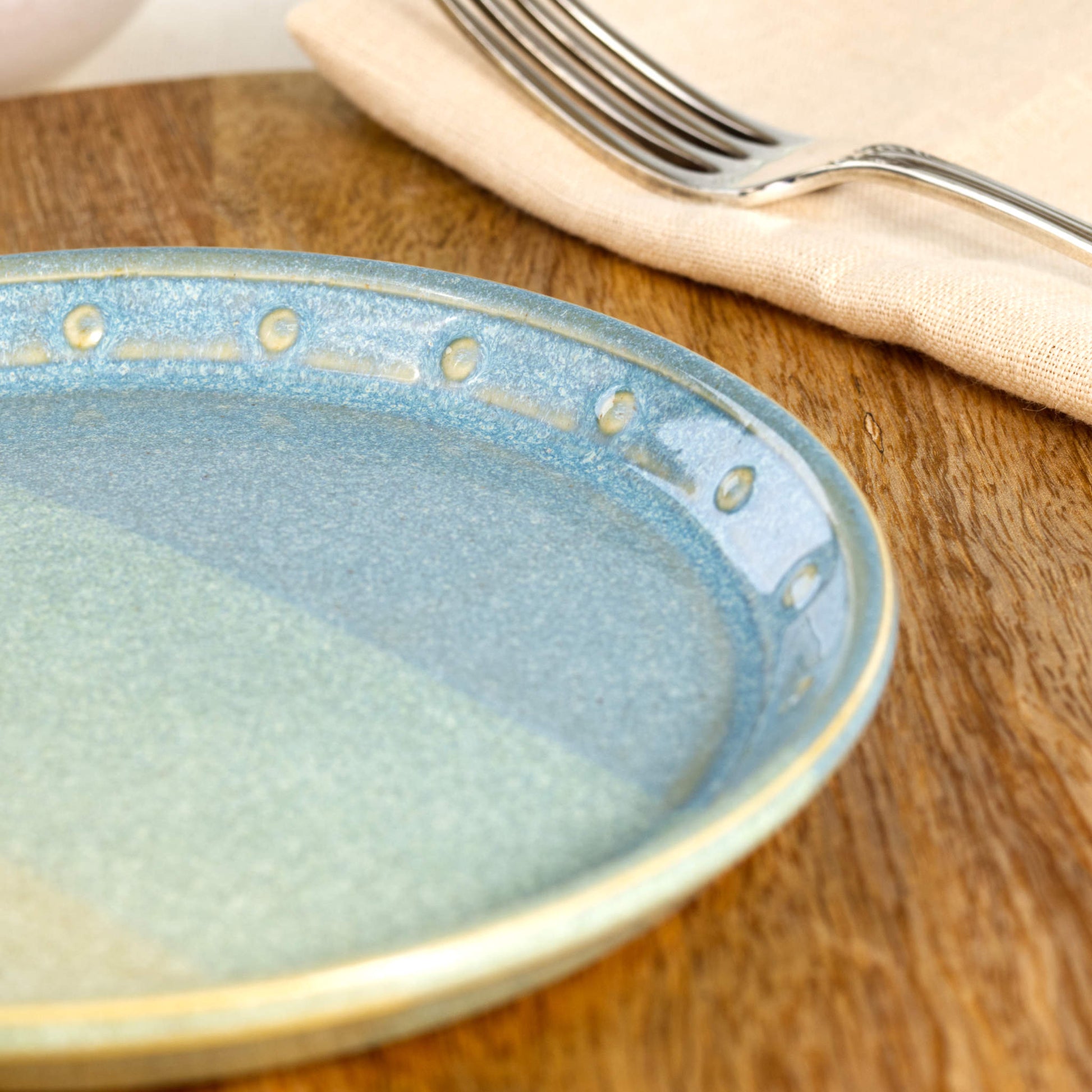 Close-up of a Coastal Blue & Pale Green ceramic small plate, highlighting the glossy speckled glaze, hand-finished dotted rim and layered blue-green tones