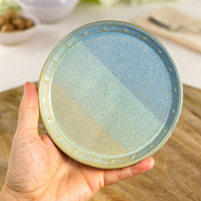 Handmade Coastal Blue & Pale Green small plate held in the hand, a wheel-thrown stoneware side plate from a British studio pottery range