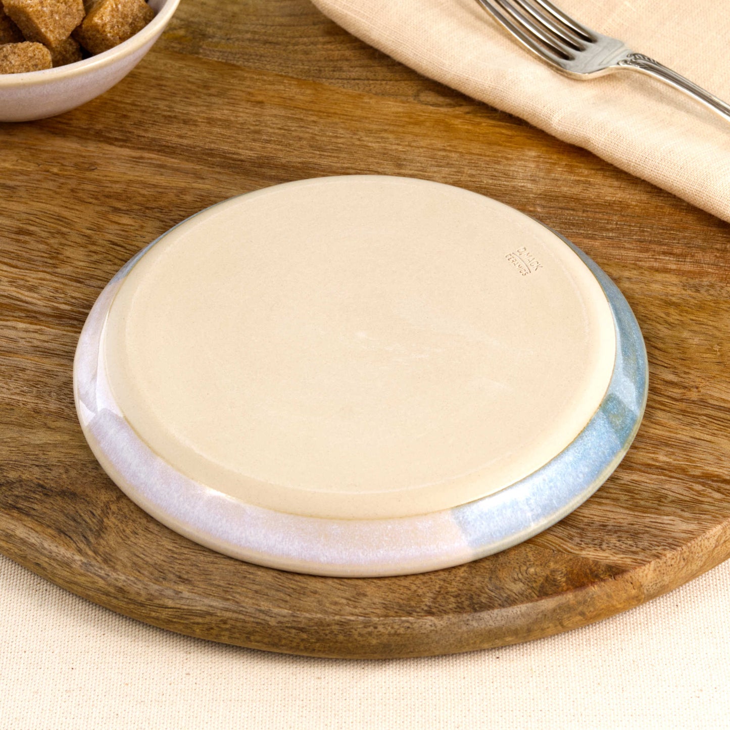 Base of a handmade Coastal Blue and White small plate, showing the smooth burnished foot and makers mark, wheel-thrown in a Sussex pottery studio