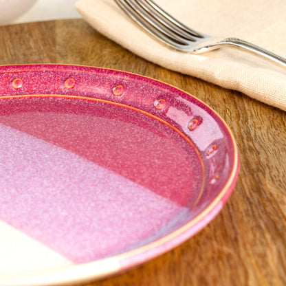 Close-up of a Crimson & White ceramic small plate, highlighting the glossy speckled glaze, hand-finished dotted rim and rich red glaze tones