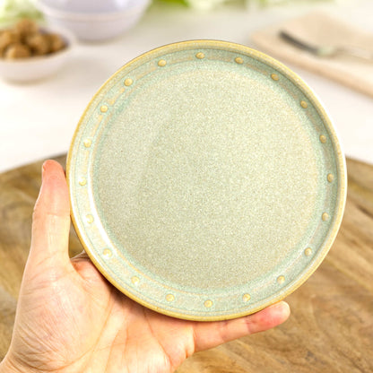 Handmade Pale Green small plate held in the hand, a wheel-thrown stoneware side plate from a small British artisan studio