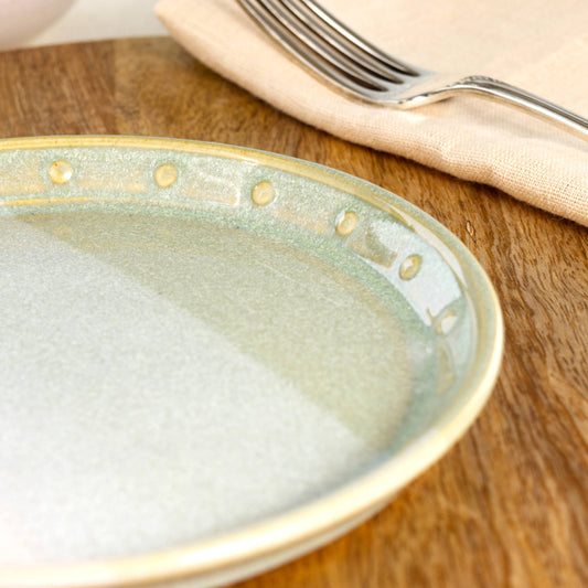 Close-up of a Pale Green & White ceramic small plate, highlighting the glossy speckled glaze, soft green tones and hand-finished dotted rim detail