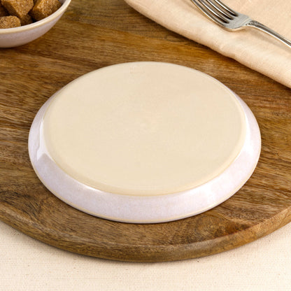 Base of a handmade white ceramic small plate, showing the smooth burnished foot and makers mark, wheel-thrown in my Sussex pottery studio