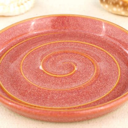 Close up of coral glazed ceramic soap dish with spiral pattern, glossy speckled Sea Smoothed Pebble signature glaze handmade stoneware bathroom tray