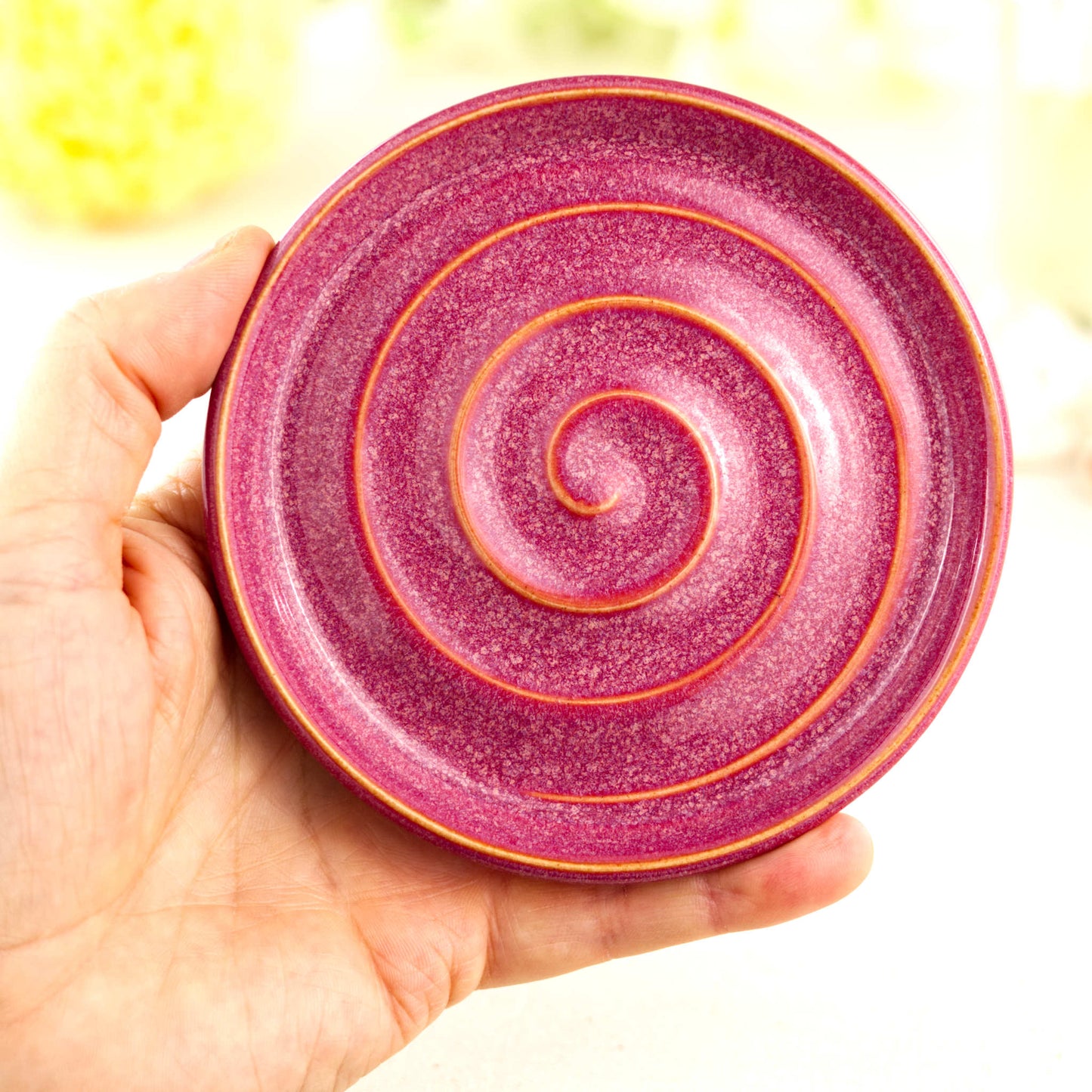 Crimson handmade pottery soap dish held in hand showing size, spiral draining design, artisan ceramic soap holder for sink or shower