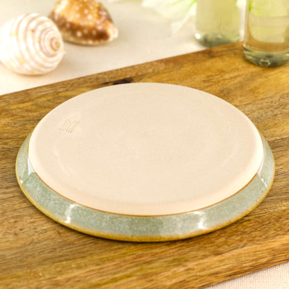 Smooth burnished base of handmade pale green ceramic soap dish also showing the artisan makers mark.