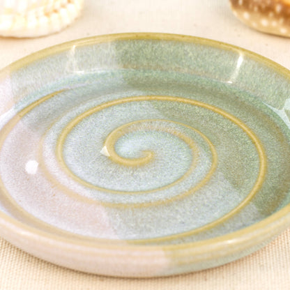 Close up of pale green and white soap dish, overlapping glazes with striped spiral design and glossy Sea Smoothed Pebble finish