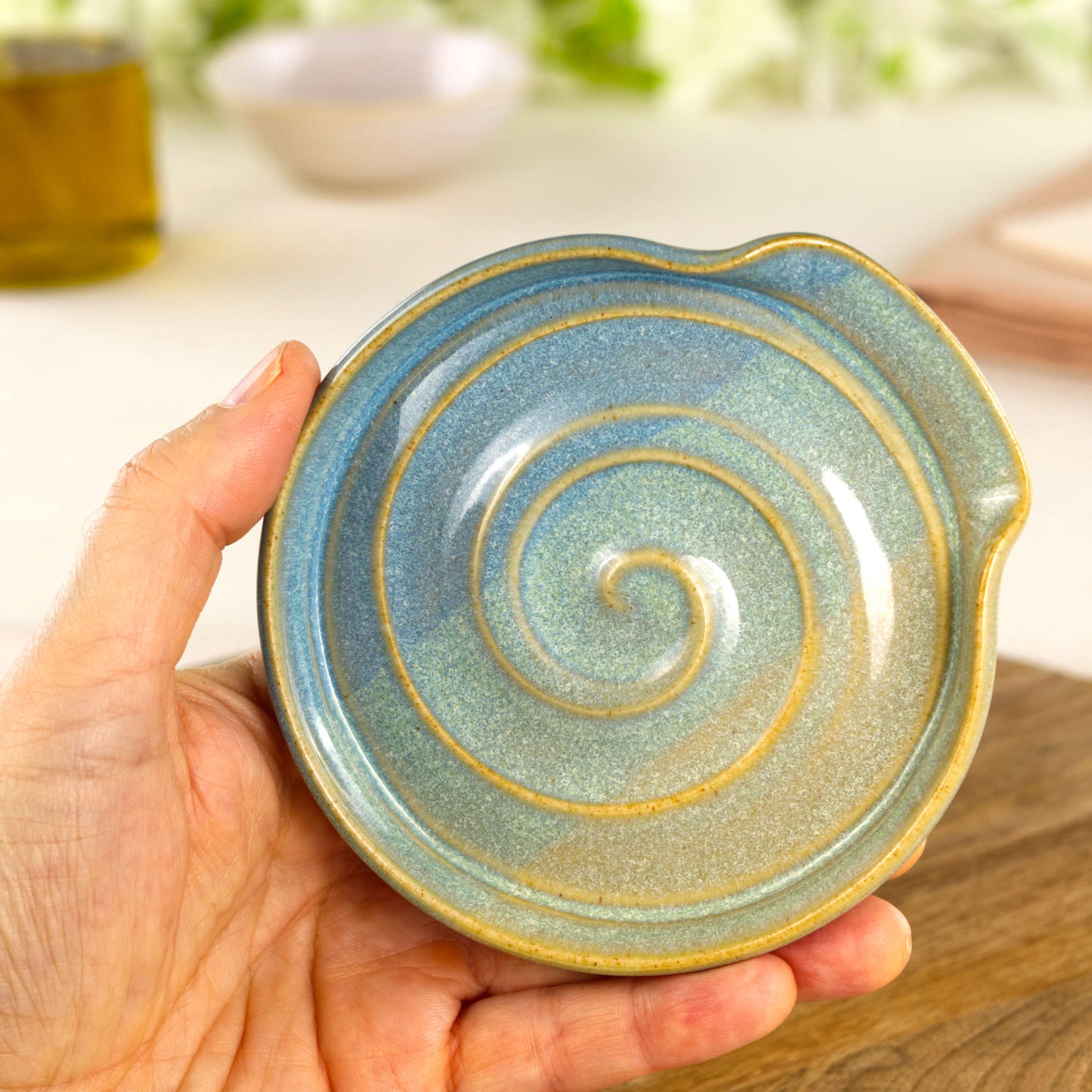 Handmade Coastal Blue and Pale Green ceramic spoon rest shown in hand, compact wheel-thrown stoneware spoon holder for kitchen worktop
