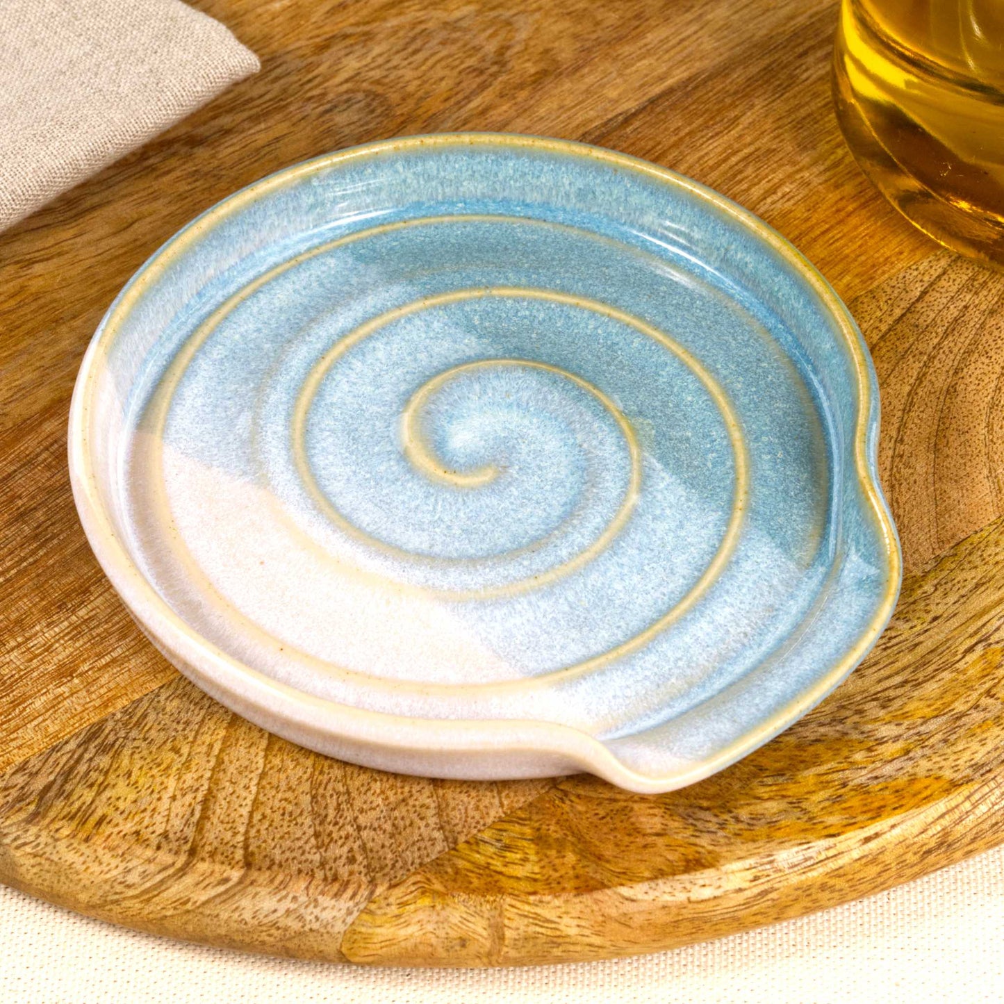 Close view of Coastal Blue and White spoon rest, flowing two tone glaze with spiral ridges and sea inspired finish