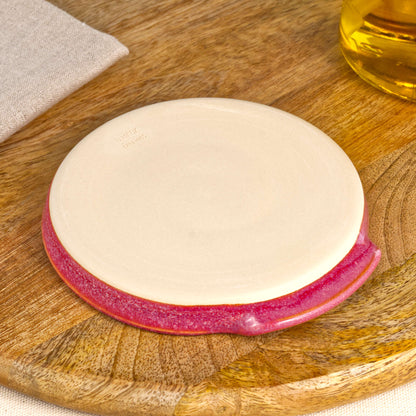 Base of handmade Crimson spoon rest with makers mark, burnished smooth underside to help protect surfaces, Sussex artisan pottery