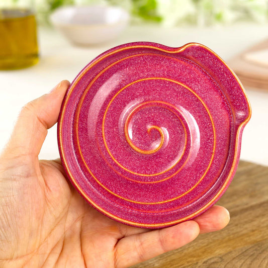 Handmade Crimson spoon rest shown in hand, compact wheel-thrown pottery spoon holder in deep red tones for modern kitchens