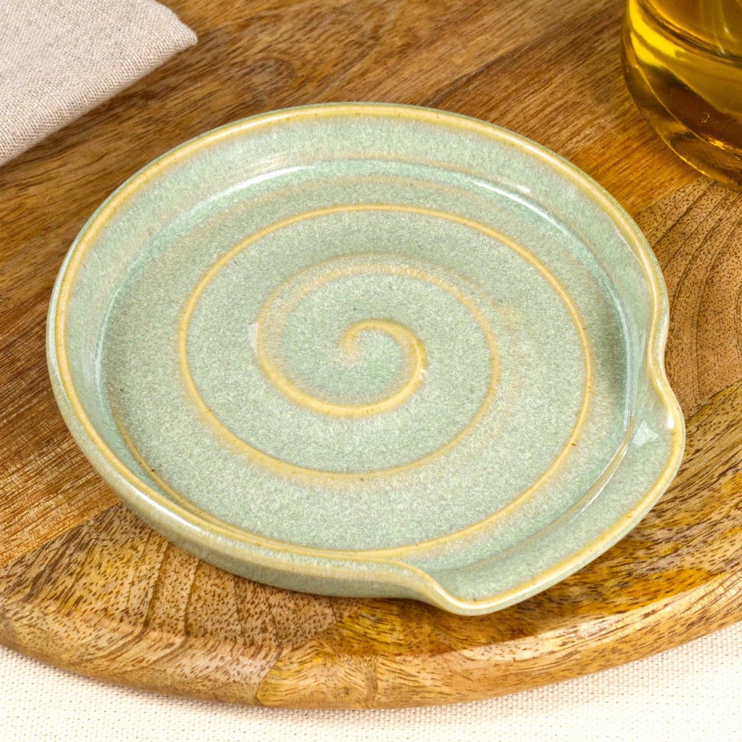 Close up of Pale Green pottery spoon rest with glossy speckled Sea Smoothed Pebble glaze, handmade ceramic utensil rest