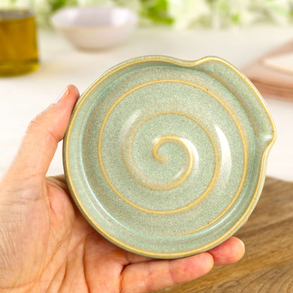 Handmade Pale Green spoon rest shown in hand, compact wheel-thrown ceramic spoon holder for kitchen counter or hob side