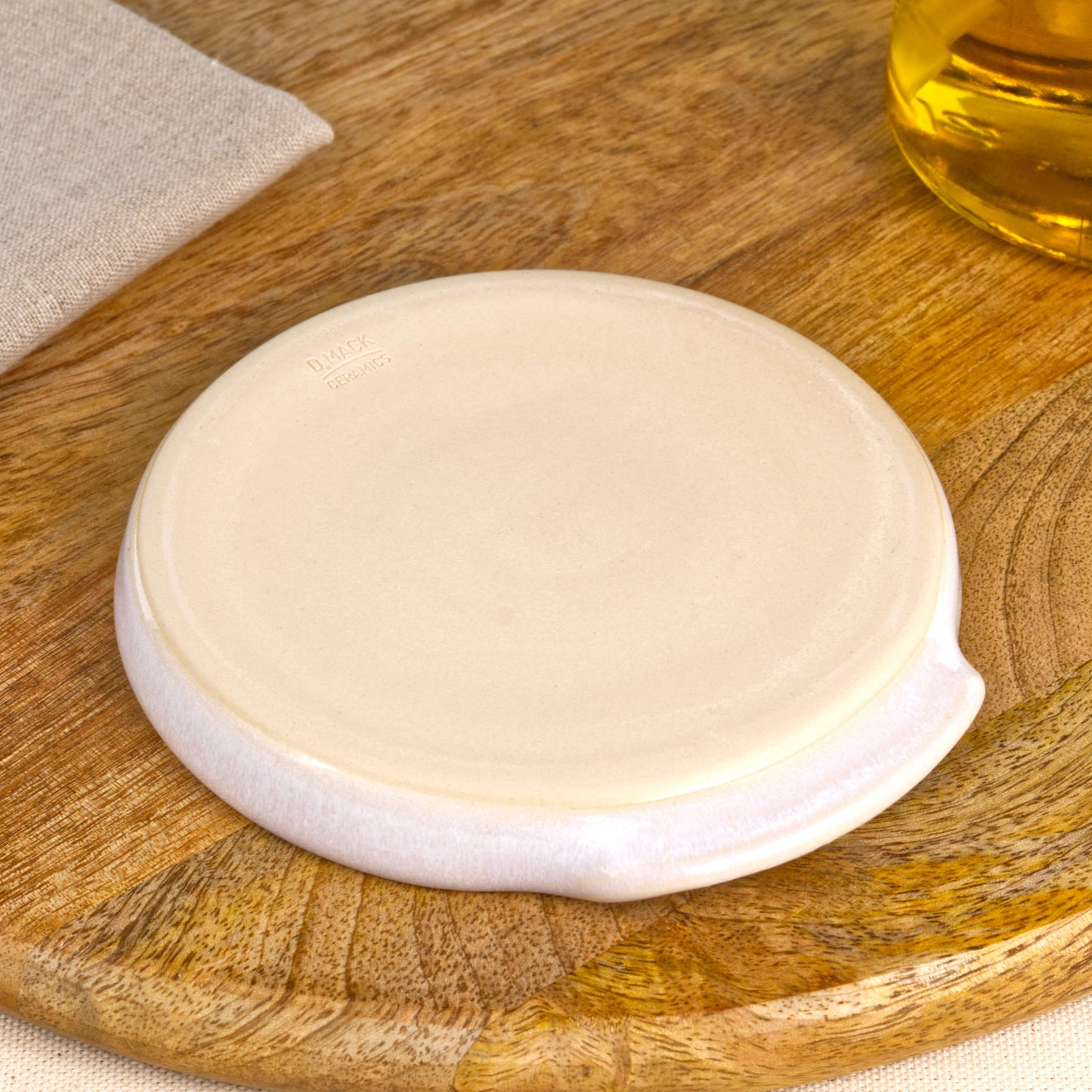 Base of handmade white spoon rest with makers mark, burnished smooth underside to help protect surfaces, Sussex artisan ceramics