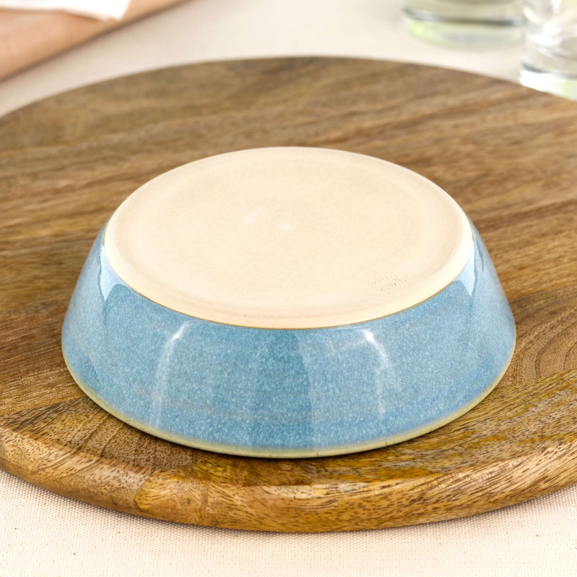 Base of a wheel-thrown Coastal Blue tapas bowl, showing the smooth burnished foot and makers mark, handmade in a small Sussex pottery studio