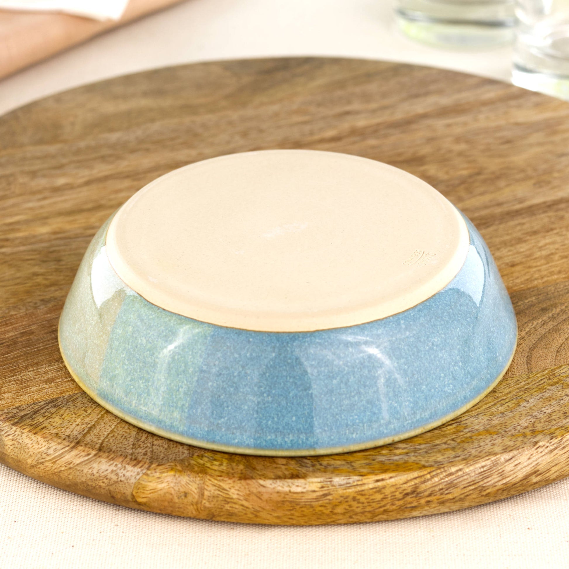 Base of a wheel-thrown tapas bowl in Coastal Blue & Pale Green, showing the smooth burnished foot and makers mark, handmade in a small Sussex pottery studio