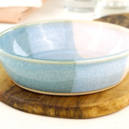 Close-up of a handmade stoneware tapas bowl in Coastal Blue & White, showing the glossy speckled glaze and shallow serving bowl shape