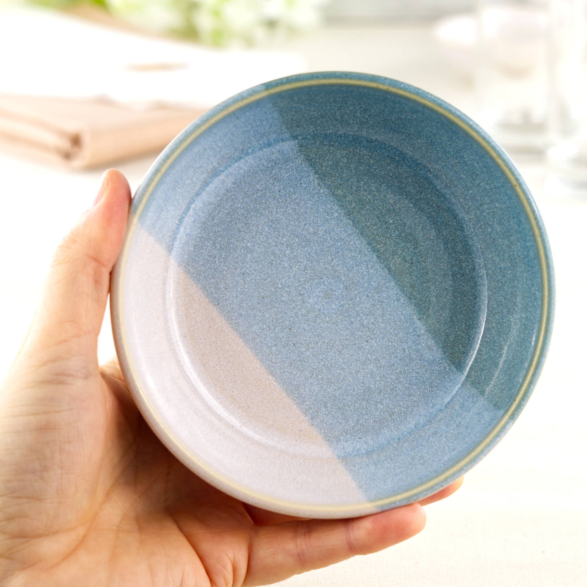 Handmade ceramic tapas bowl held in the hand, with Coastal Blue & White glazes and a flatter interior designed for small plates, dips and sharing food