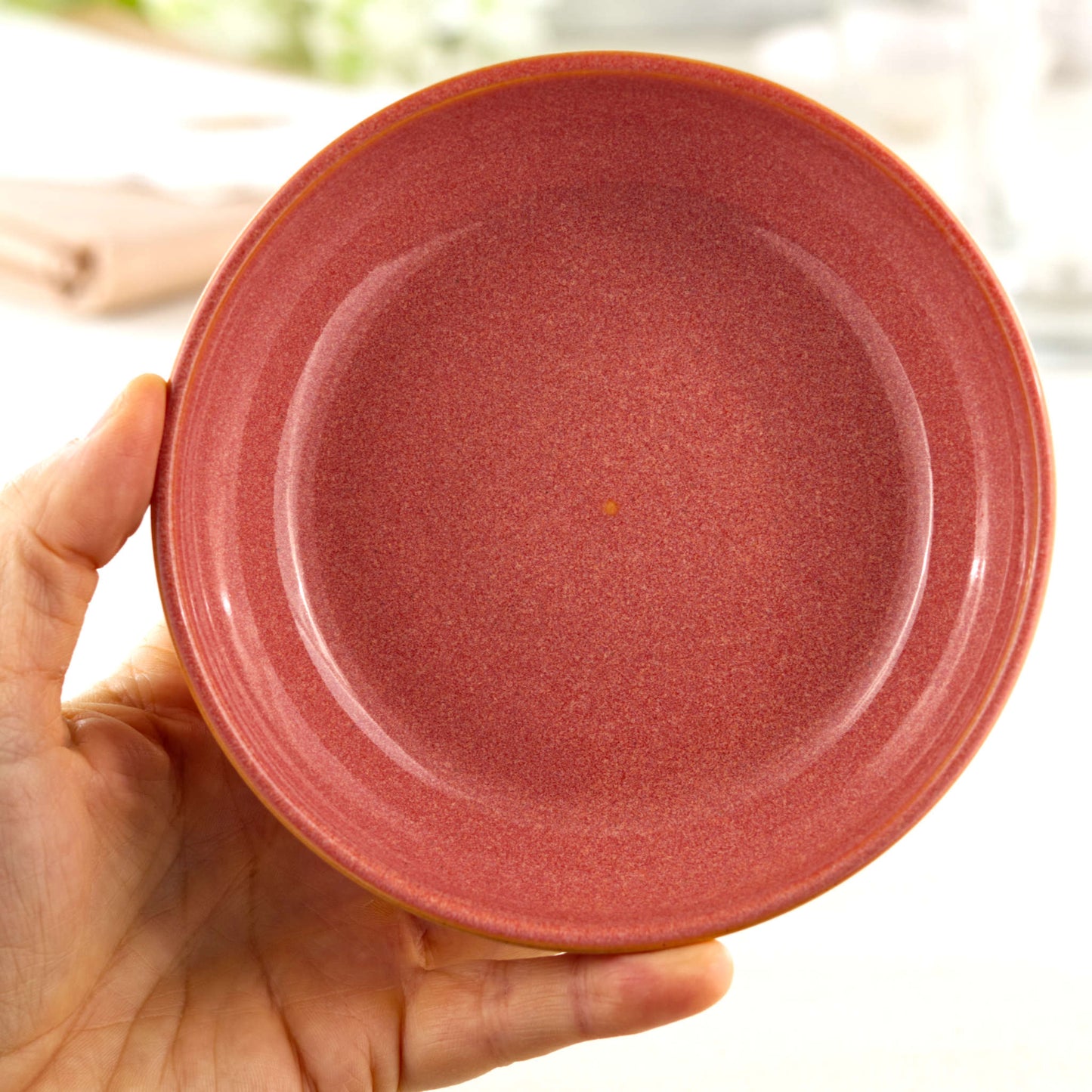Handmade Coral ceramic tapas bowl held in the hand, a piece of British studio pottery sized for dips, olives, side dishes and everyday nibble bowls